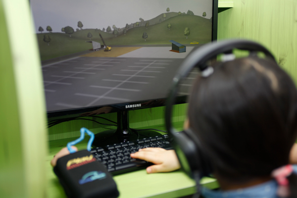 4. 뇌움핏 뇌파 집중력 프로그램 훈련. 아이가 뉴로피드백 센서를 통해 자신의 집중력을 조절하며 화면의 게임을 진행하는 모습.